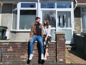 Marcus and his partner sitting on a wall outside of their property