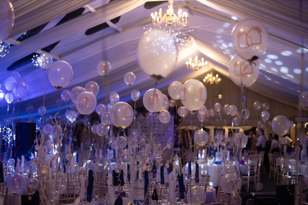 A room with balloons floating above tables