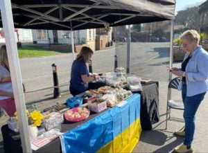 A charity stall with the Ukraine flag draped on the front